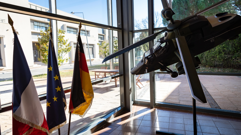 Maquette d'hélicoptère Tigre, aux côtés des drapeaux français, allemand et européen.